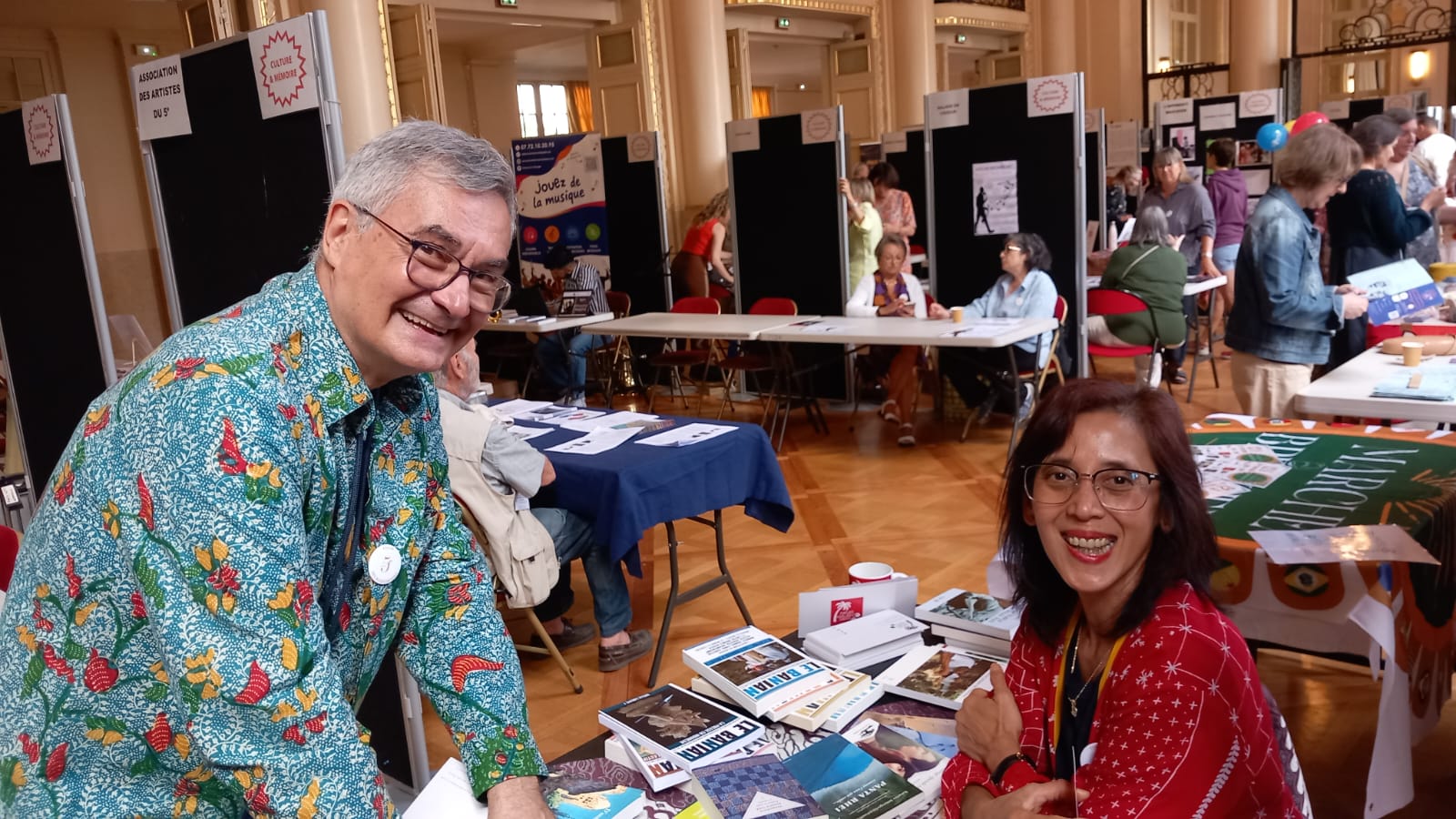 Deux membres de Pasar Malam au stand, entourés des publications de l'association