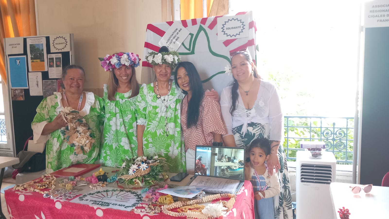 Membres de l'association tahitienne A Tautiru Ia Na Paris devant leur stand fleuri